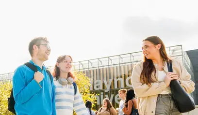 Students outside smiling and walking