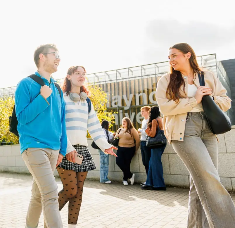 Students outside smiling and walking