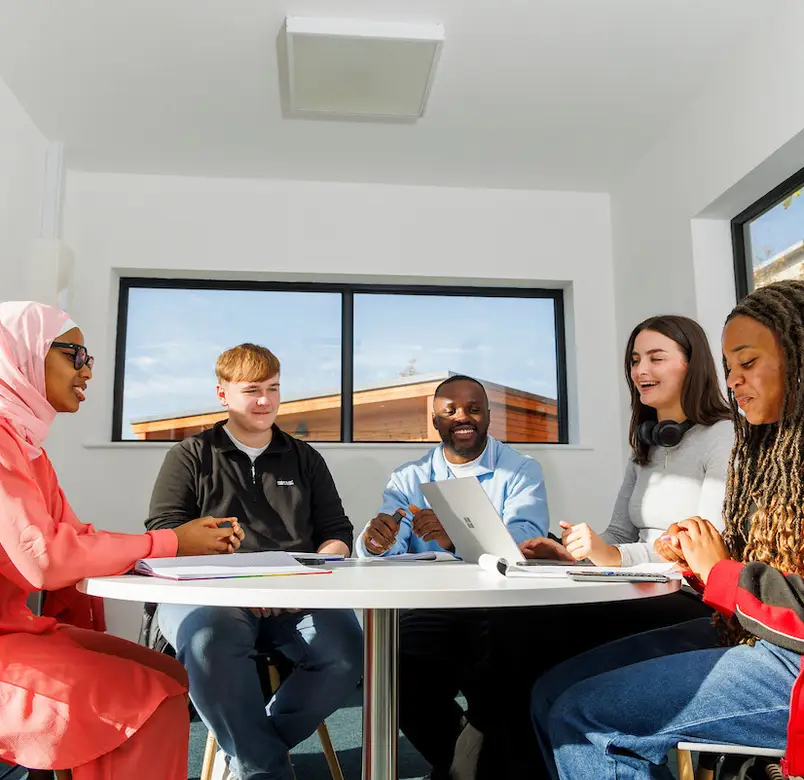 Students sit around a table in our North Campus group work space