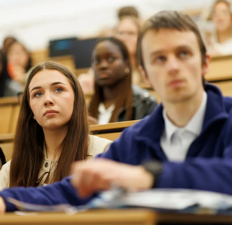 A close shot of two students attending a lecture