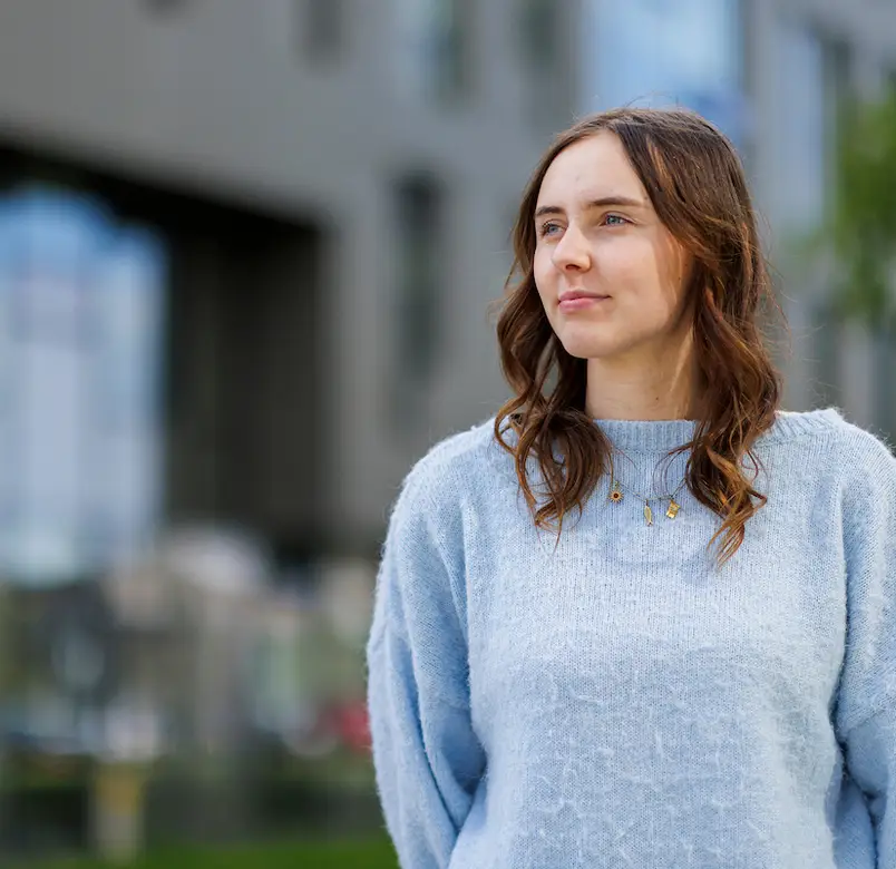 A student looks off to the right of the image