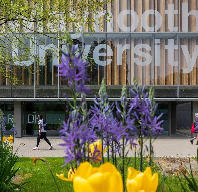 The university library with spring flowers in the foreground of the image