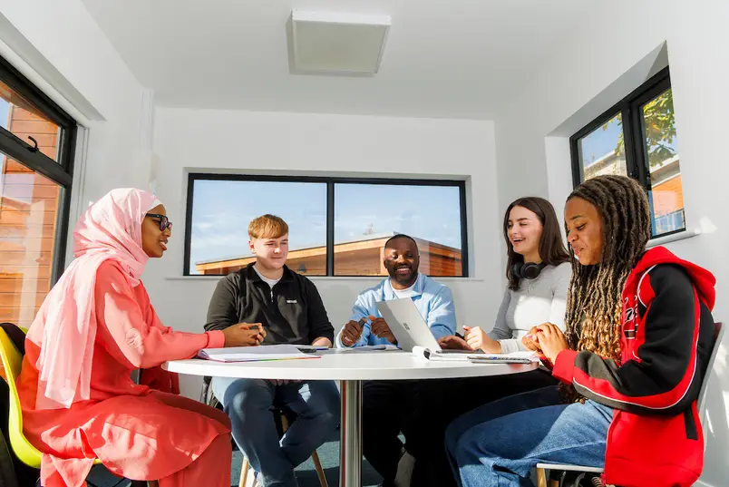 Students sit around a table in our North Campus group work space