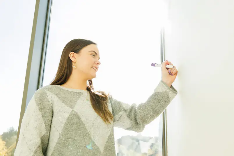 A student writes on a whiteboard