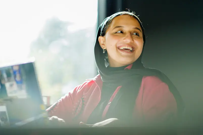 A student looks to someone off camera and smiles