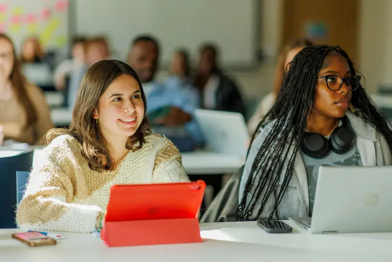 Two students sit at a table during a class