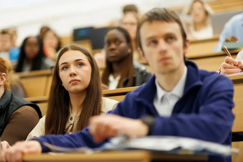 A close shot of two students attending a lecture