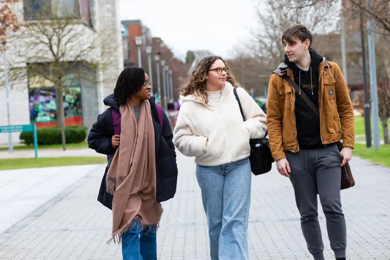 A group of students in warm jacket walk on campus