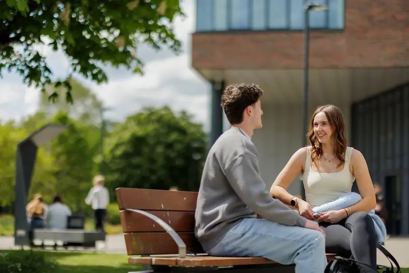 MU students talking on a bench outside TSI Building on North Campus